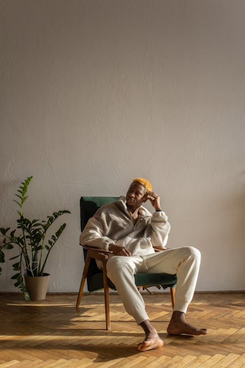 A Man in Brown Fur Coat Sitting on a Chair