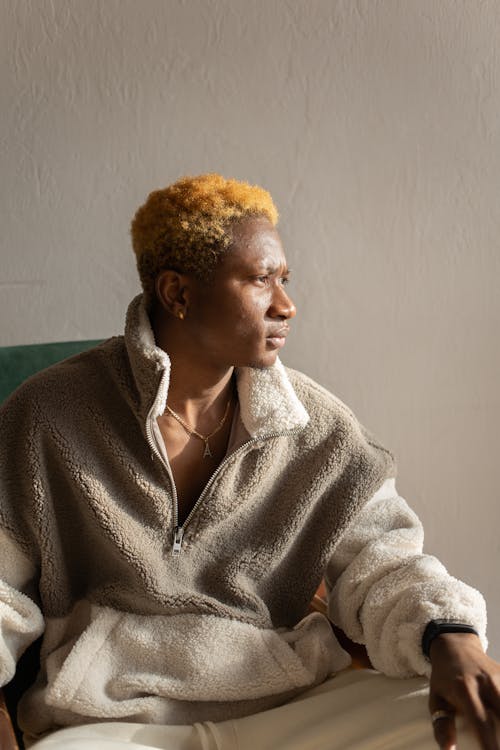 A Man in Brown Fur Coat Sitting on a Chair