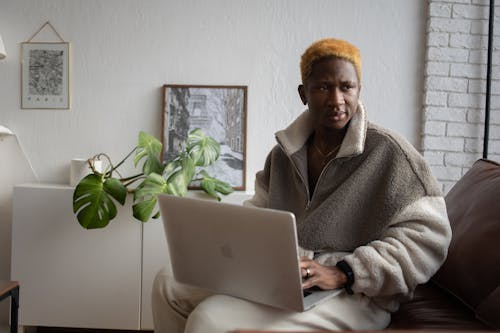 Free A Man in Brown Fur Coat Using a Laptop while Sitting Stock Photo