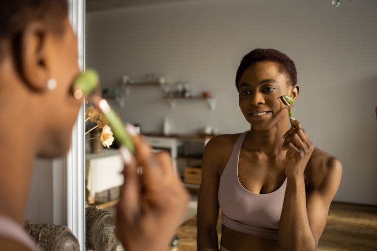 A Woman Using A Jade Roller