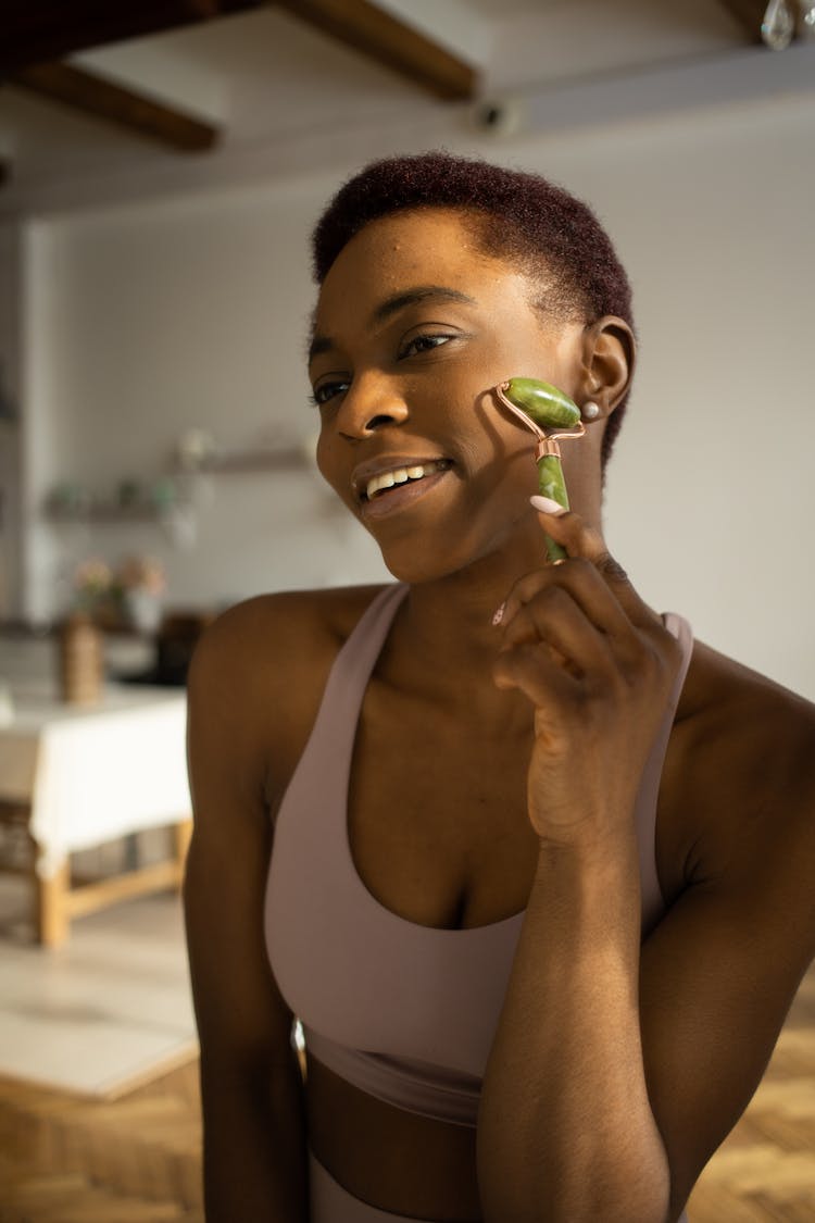 A Woman Using A Jade Roller