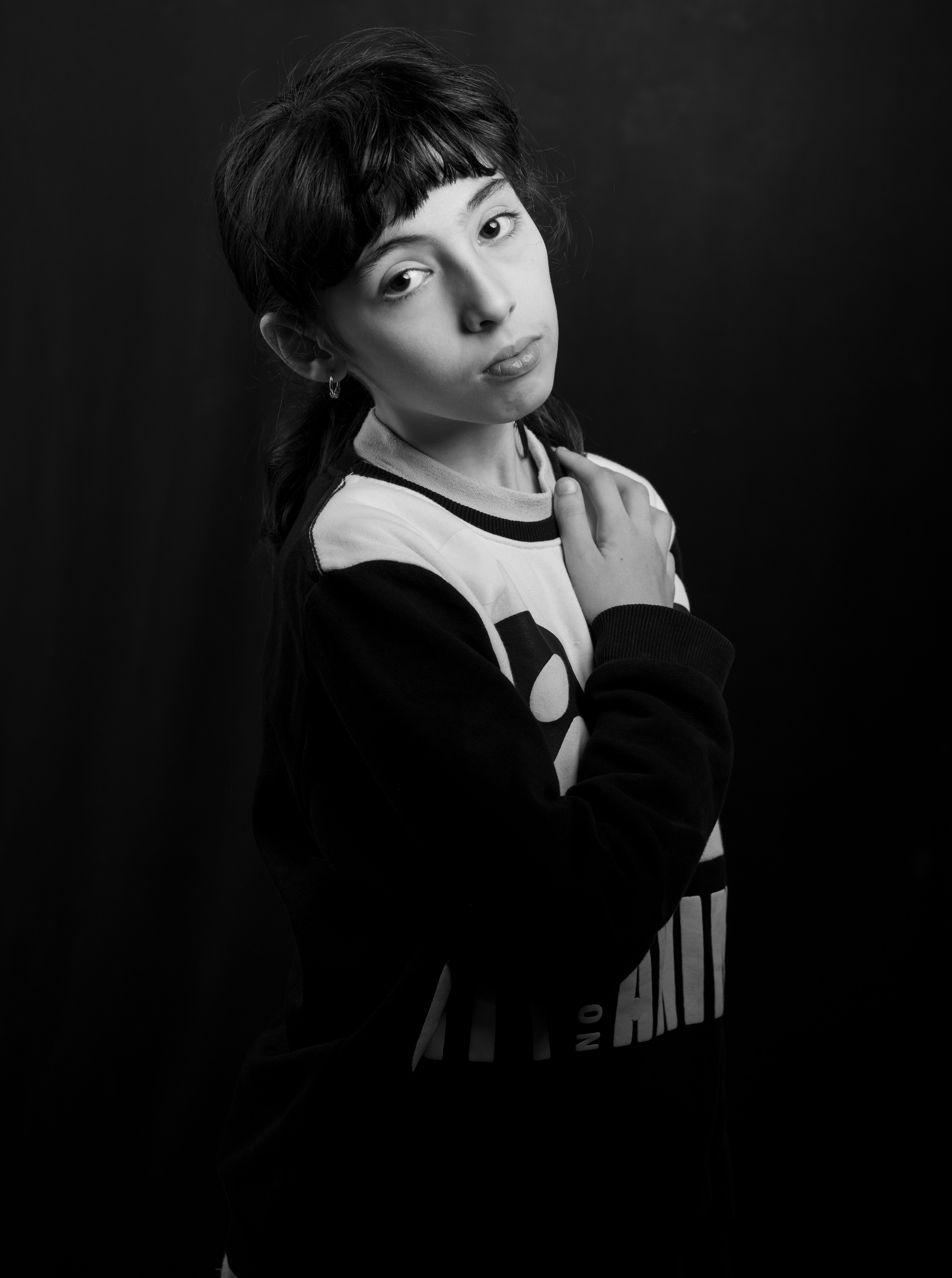 A striking black and white portrait of a young woman posing thoughtfully.