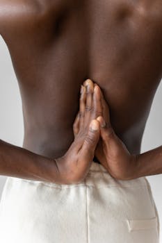 Close-up of a person practicing yoga with a focus on reverse prayer pose hands.