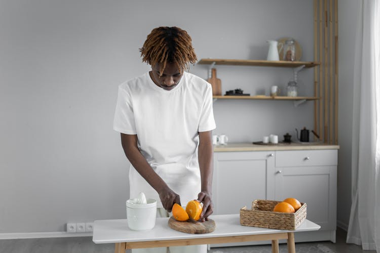 Man In White Shirt Slicing Orange