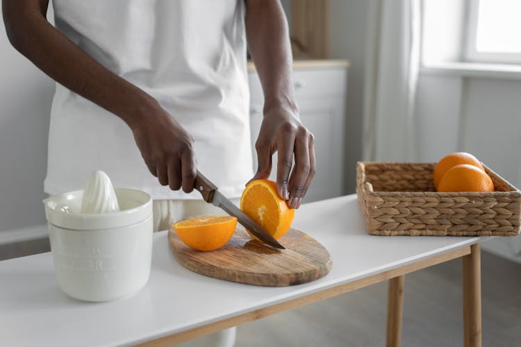 Close-Up Shot Of A Person Slicing An Orange