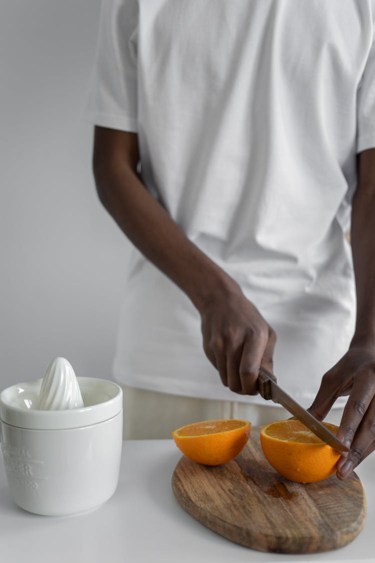 Close-Up Shot Of A Person Slicing An Orange