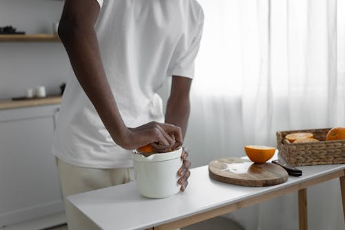 Close-up Photo of Man Squeezing an Orange 
