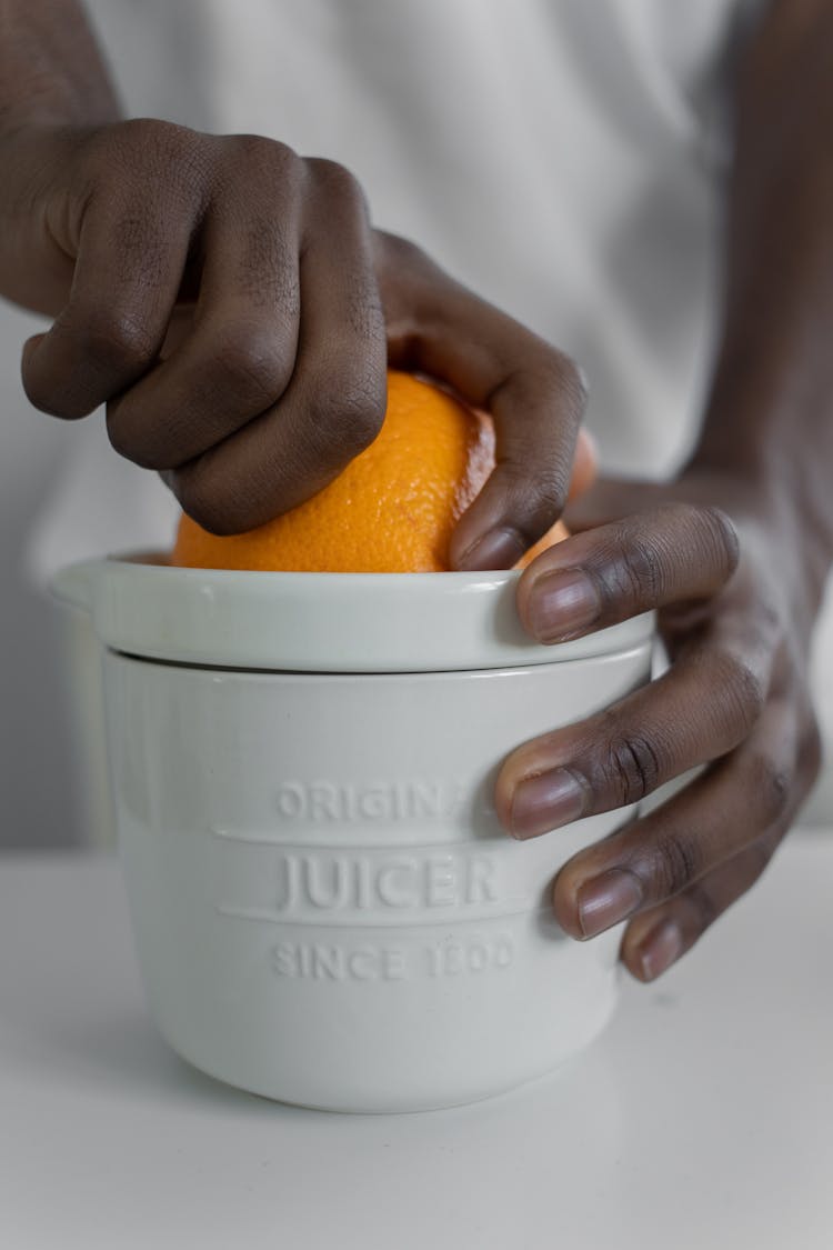 Person Squeezing Orange Fruit