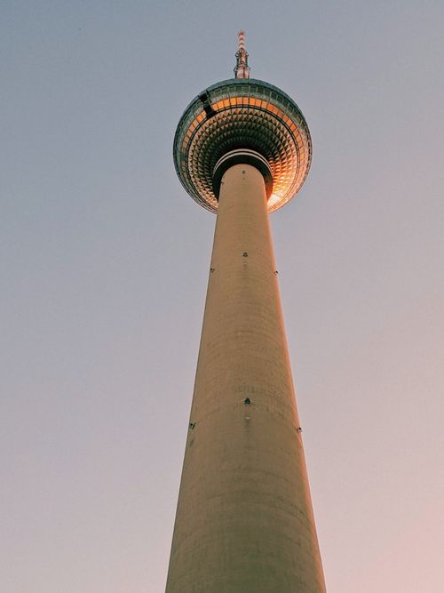 Free A dramatic low-angle shot of the Berlin TV Tower illuminated against a clear evening sky, showcasing its iconic structure. Stock Photo