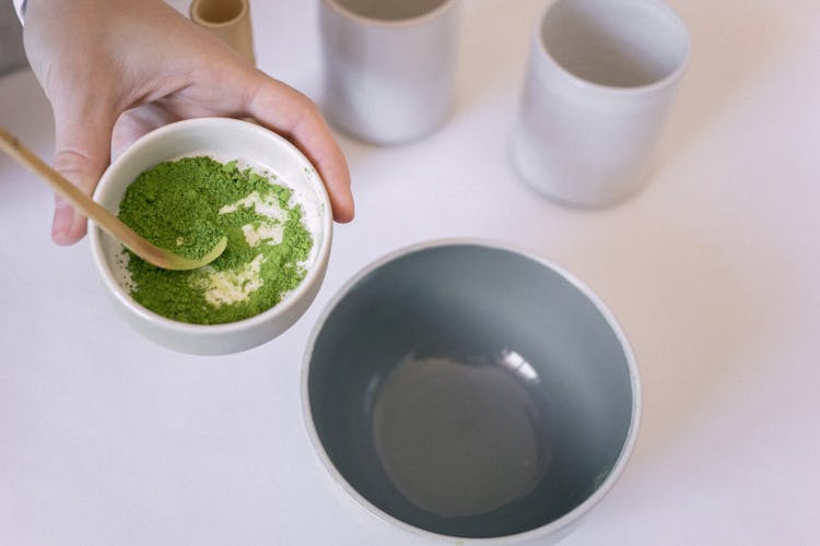 Hand Holding A Bowl With Matcha Powder 