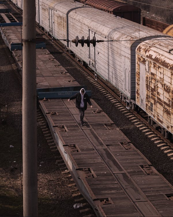 Free Man in Black Jacket Walking on Train Car Platform Stock Photo