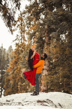 A couple embraces in a snowy forest in Gulmarg, capturing a romantic winter moment.