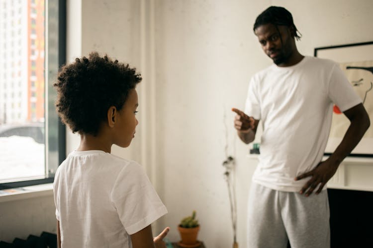 Young Black Father Edifying Calm Son At Home