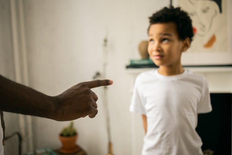 Upset Little Ethic Boy Looking At Faceless Father During Argument