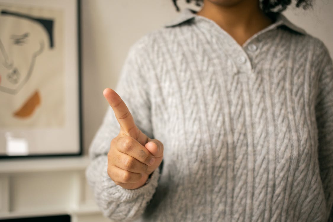 Free Black woman pointing finger in light room Stock Photo