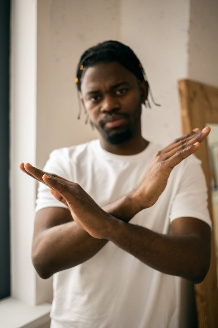 Serious Black Man Crossing Arms As Sign Of Restriction In Light Room