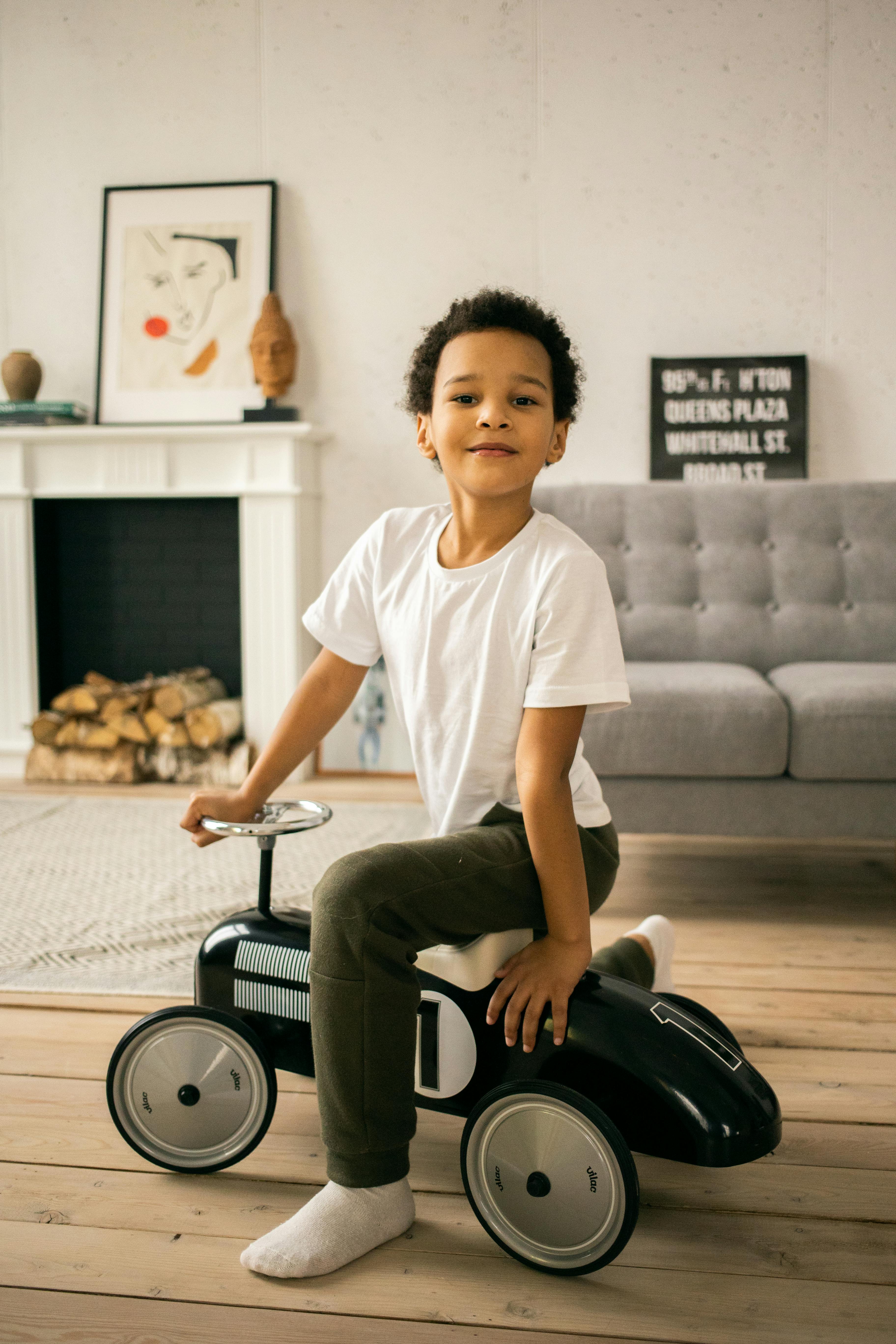 cheerful black boy on toy car