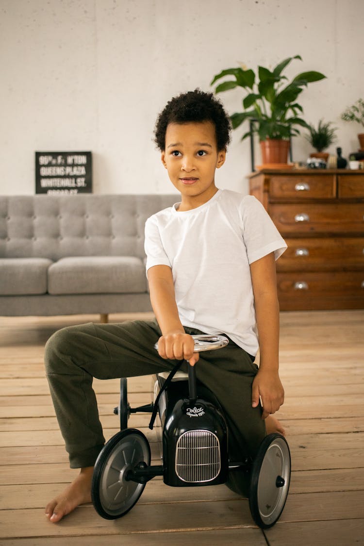 Cute Black Boy On Toy Car