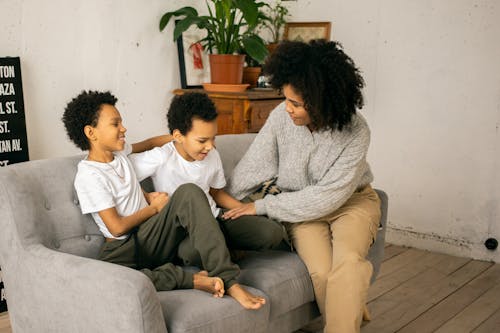 Free Black mother with positive sons on couch Stock Photo
