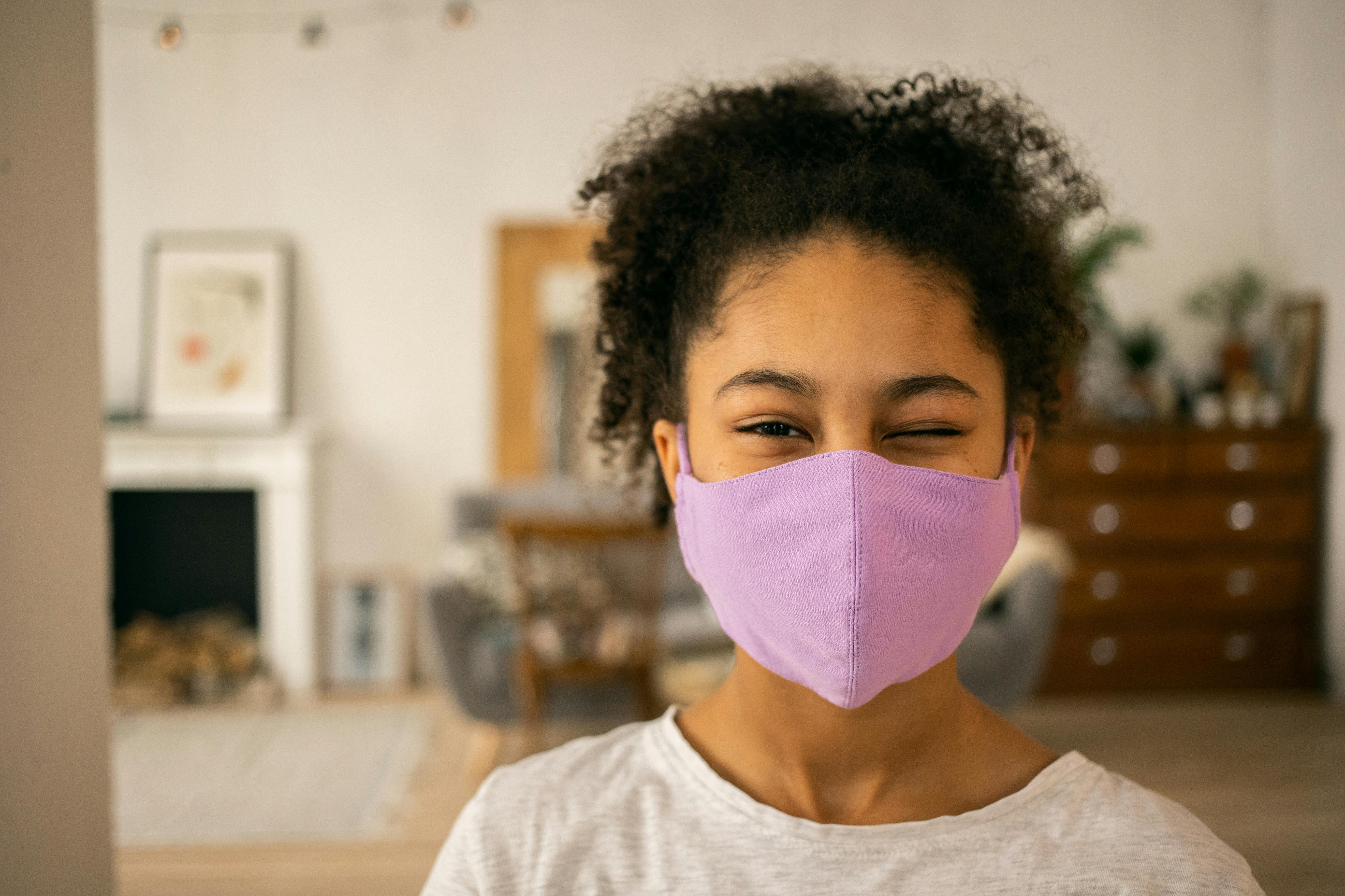 positive black girl in medical mask in room