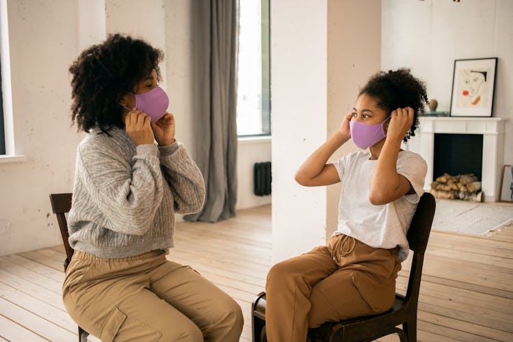 Black Woman With Girl Putting On Medical Masks