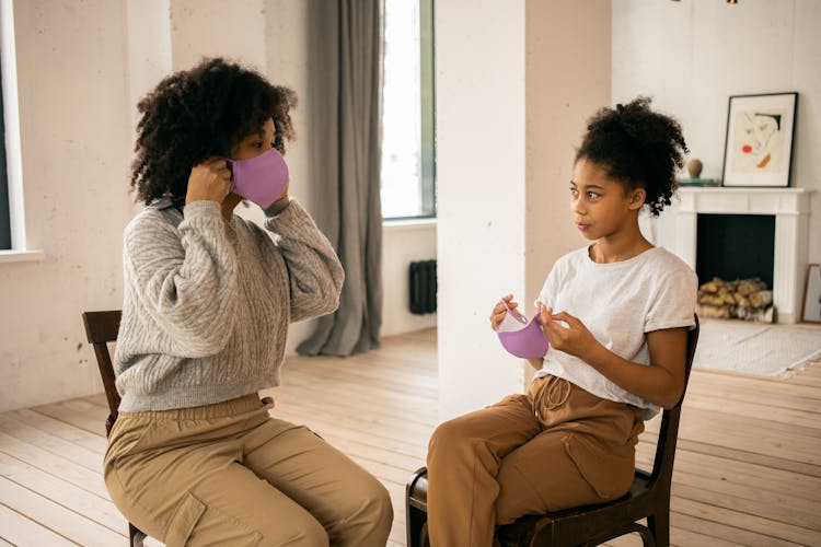 Black Mother And Daughter Taking Off Medical Masks