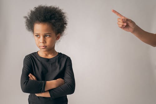 Faceless person punishing black girl