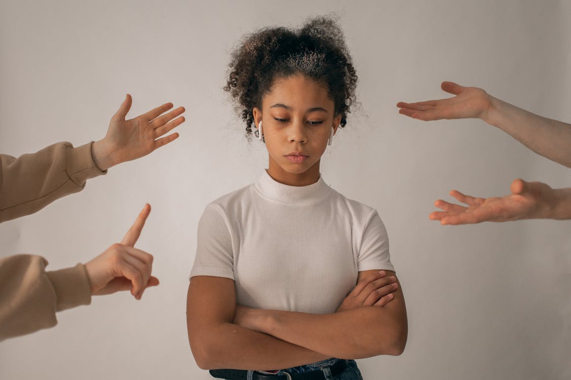 Faceless people scolding discontent girl