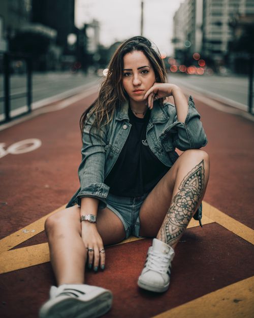 Free Stylish young woman sitting confidently on a city bike path. Stock Photo