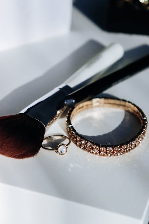 Close-up Photo of Bracelete and Make-up Brush 
