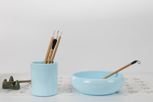 Free Light Blue Ceramic Bowl and Pencil Holder With Calligraphy Tools Stock Photo