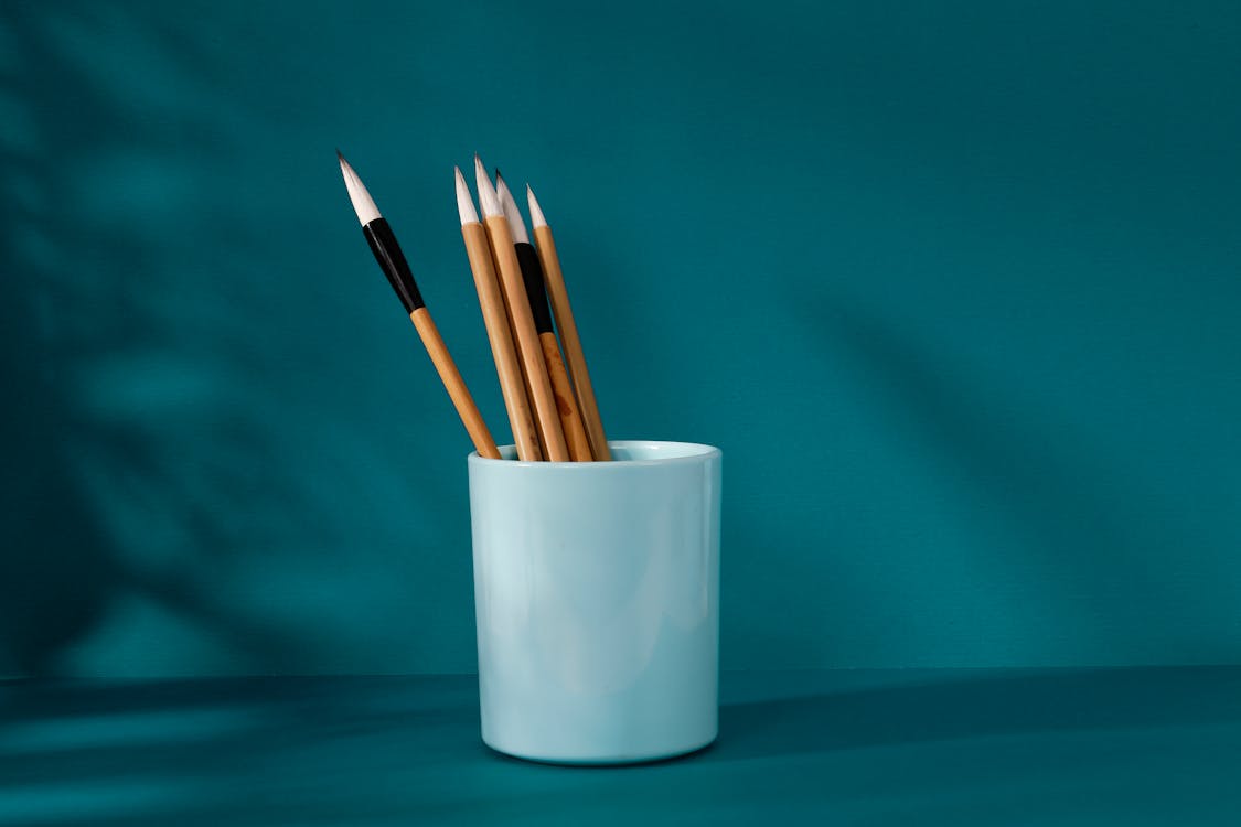 Free Sharpened Wooden Pencils in a White Ceramic Container Stock Photo