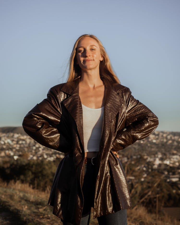 Blond Woman In Brown Snakeskin Leather Jacket Standing On Field