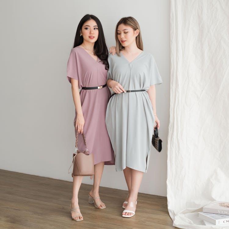 Two Pretty Women In A Dress Holding Handbags