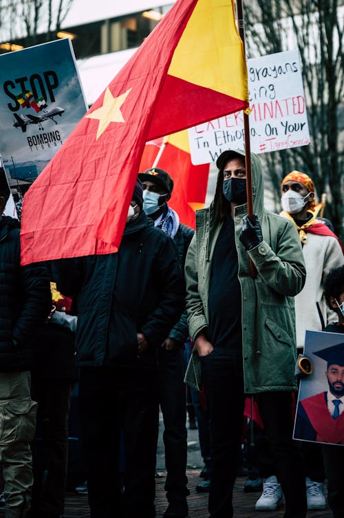 Crowd of anonymous black demonstrators protesting against war on city street