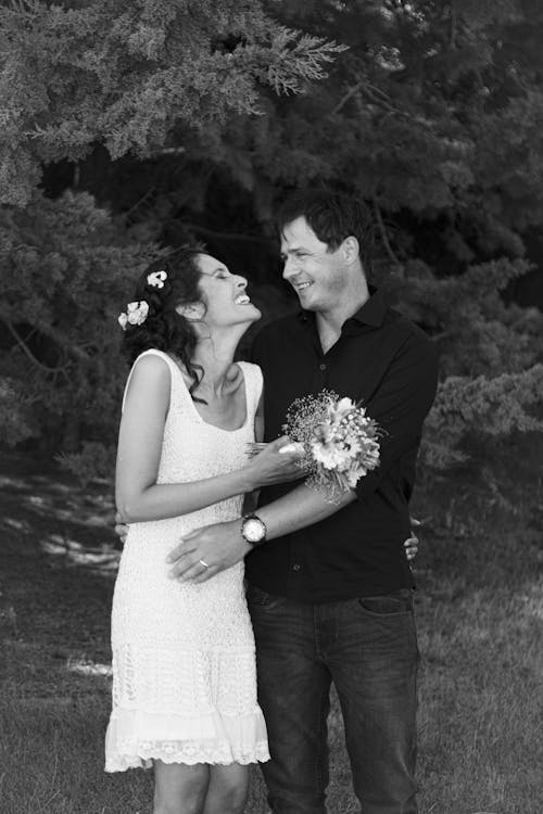 Free Grayscale Photo of Man and Woman Holding Bouquet of Flowers Stock Photo