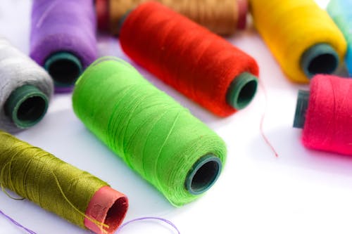 Close Up Photo Of Assorted Sewing Threads In Spools