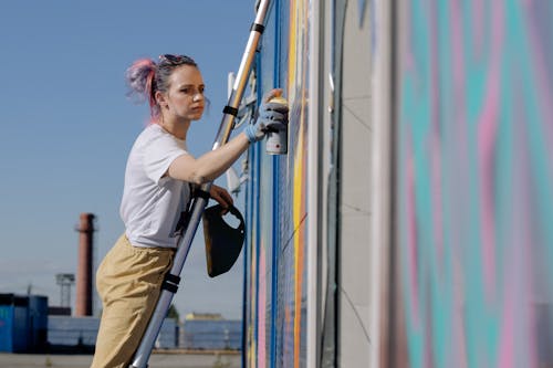 A Woman Doing a Graffiti on a Wall