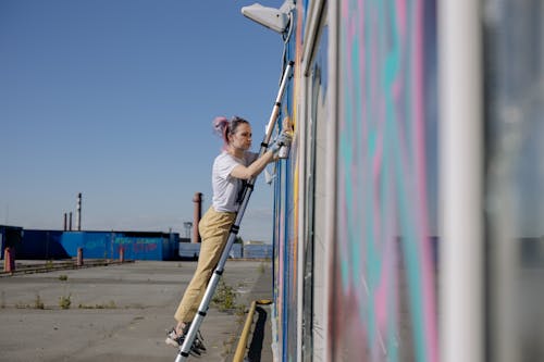 A Woman Doing a Graffiti on a Wall