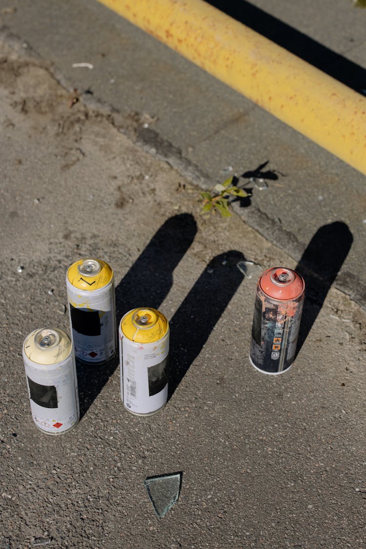 Colorful Spray Paints Placed On Asphalt Ground On Street