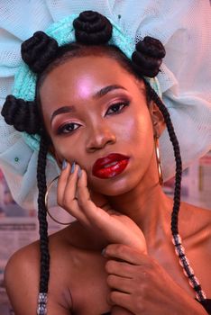 Close-up portrait of a stylish woman with braided hair and vibrant makeup, emphasizing elegance and beauty.
