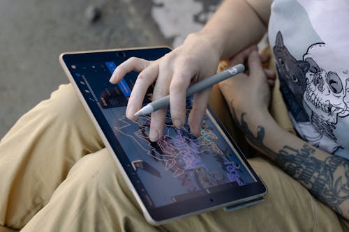 A Person Using a Tablet and a Stylus Pen