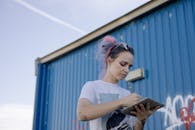 Woman in White Shirt Holding Digital Tablet and Stylus
