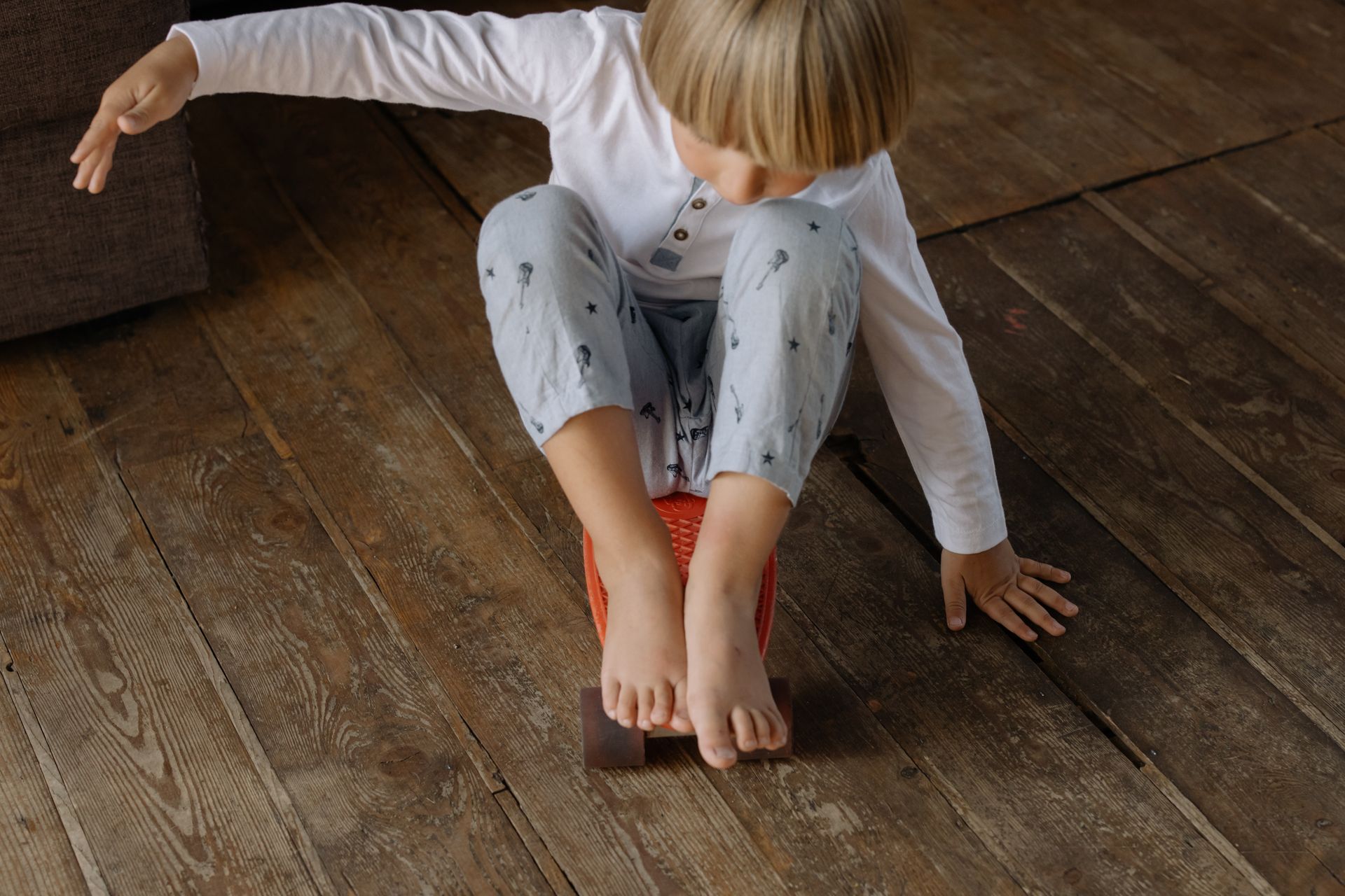 Photo of a Boy Sitting on a Penny Board