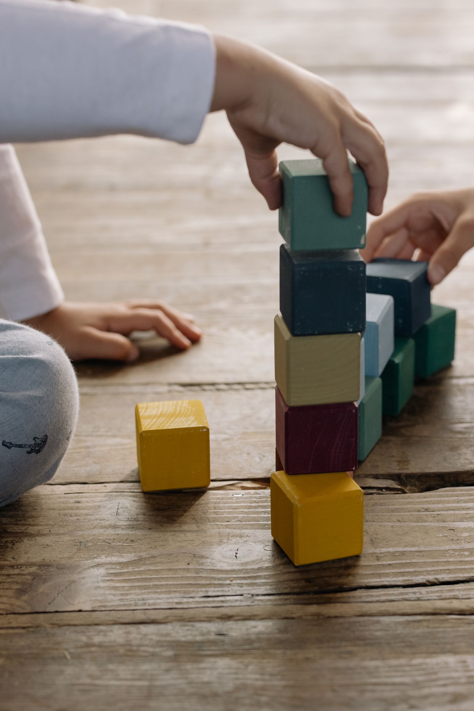Children stacking and balancing colorful wooden blocks together