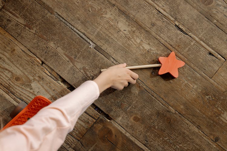 A Hand Picking The Wooden Wand On The Floor