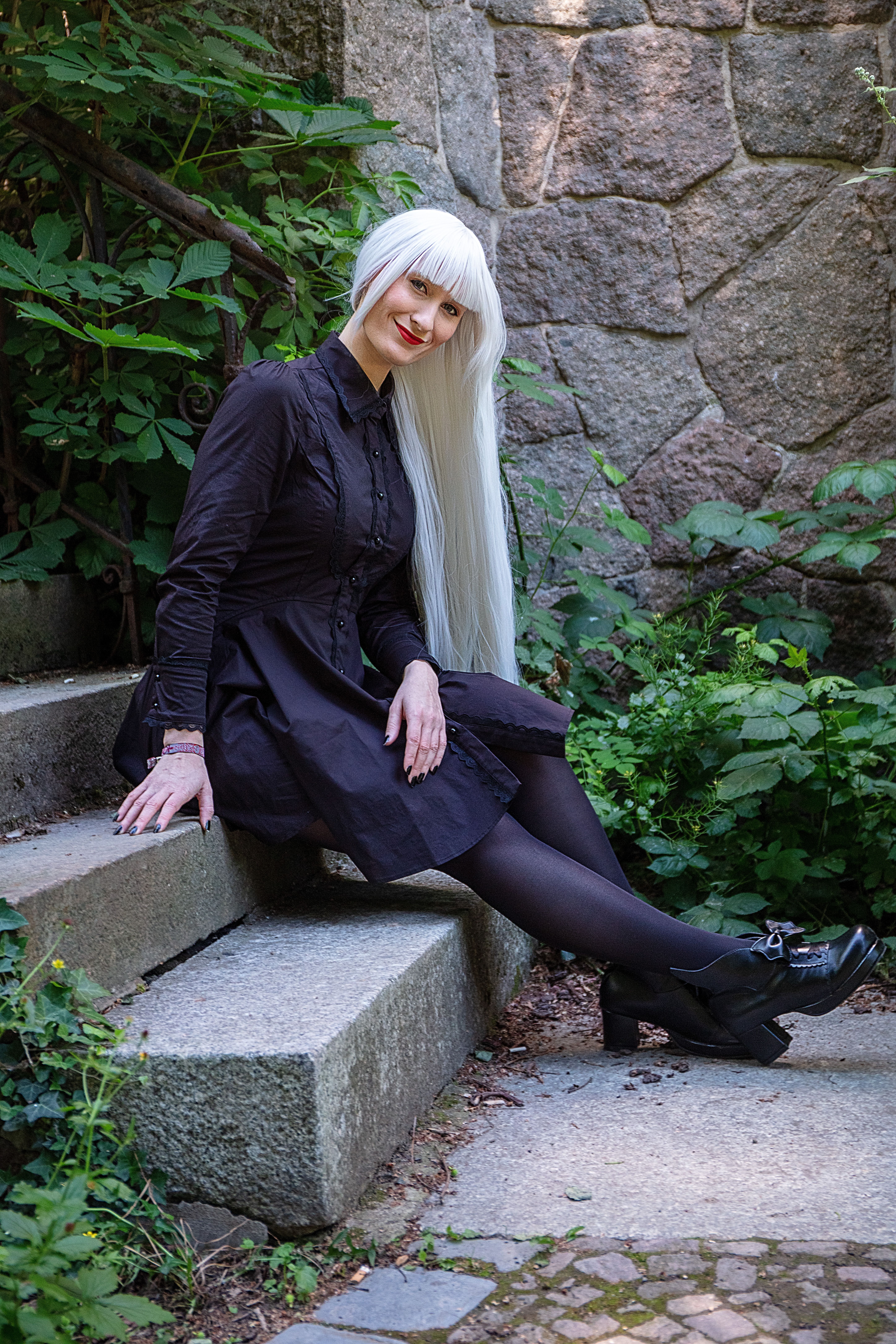 Woman in Black Dress Sitting on a Concrete Stairs · Free Stock Photo