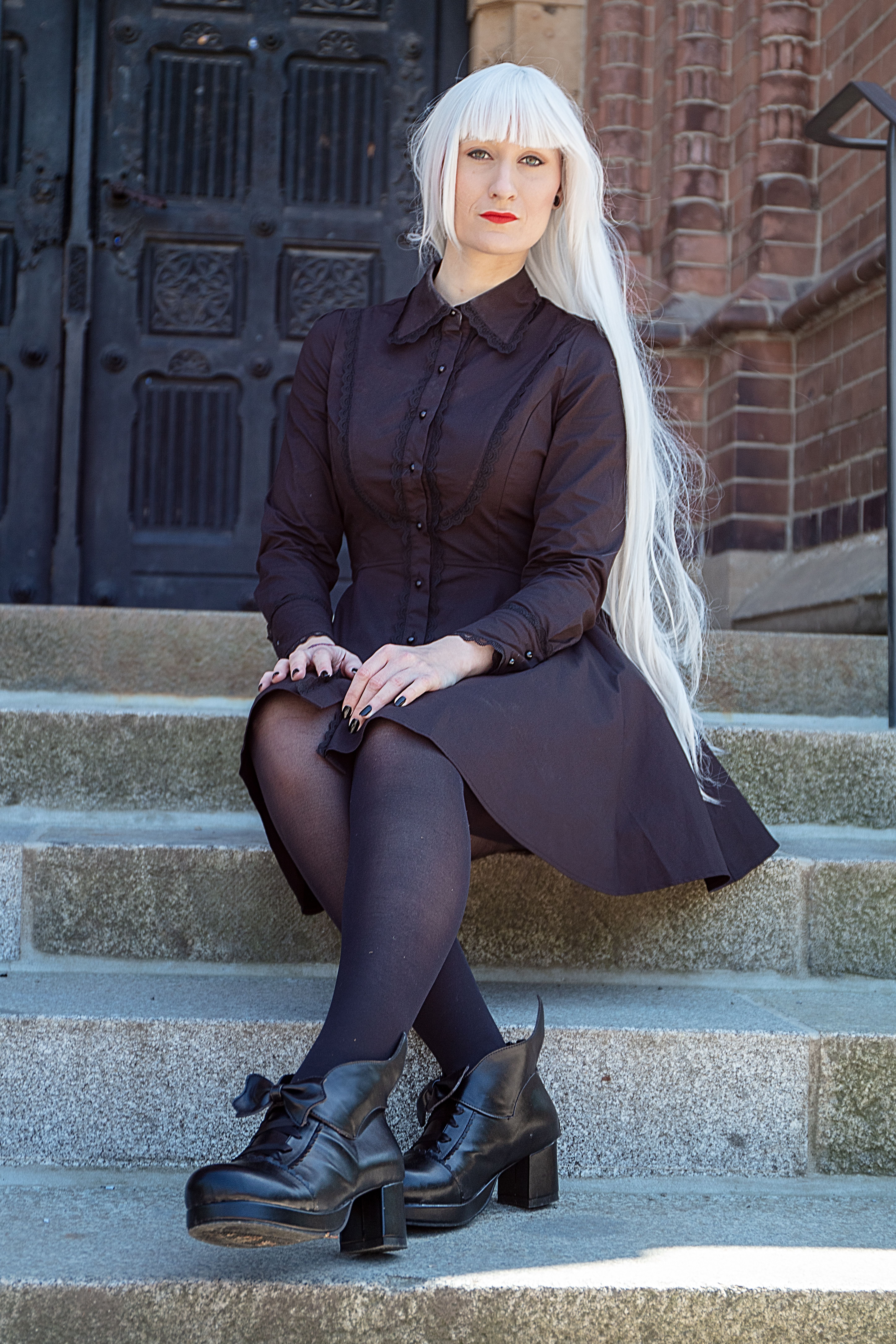 Woman in Black Dress with White Long Hair Sitting on a Concrete Stairs ...