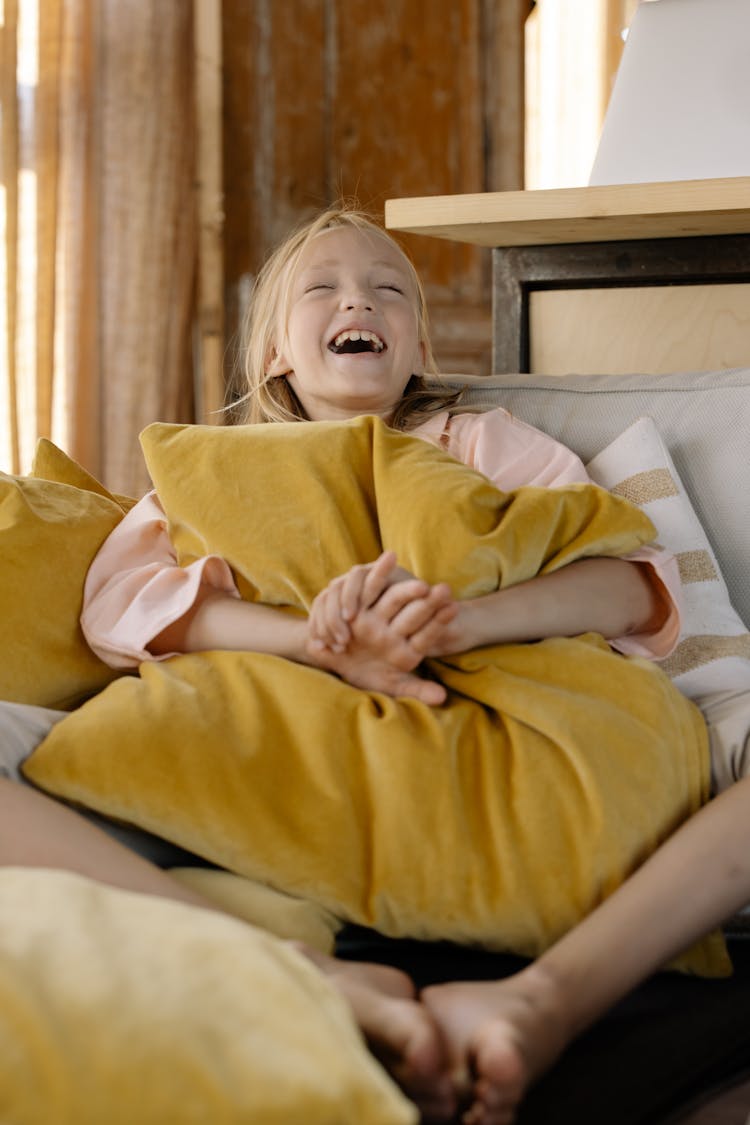 Laughing Girl Hugging A Pillow