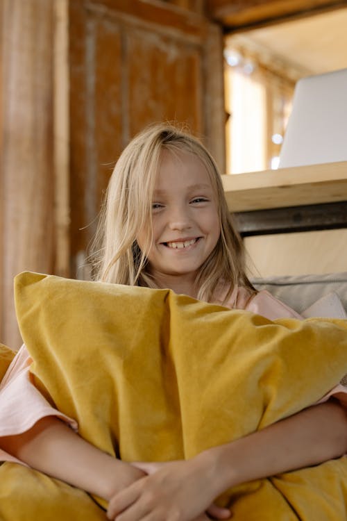 Happy Girl Holding Yellow Throw Pillow